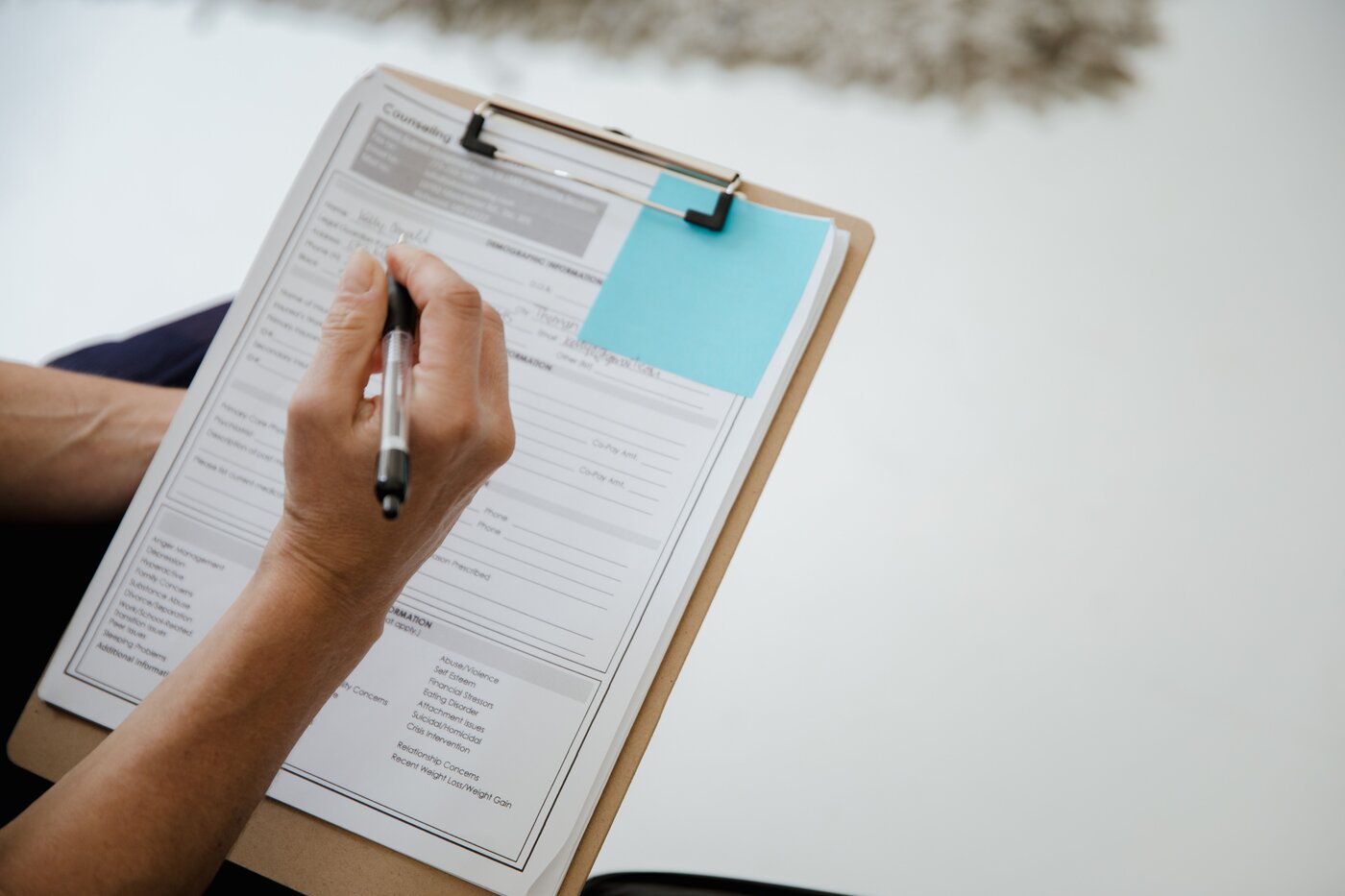 Patient completing intake paperwork on a clipboard